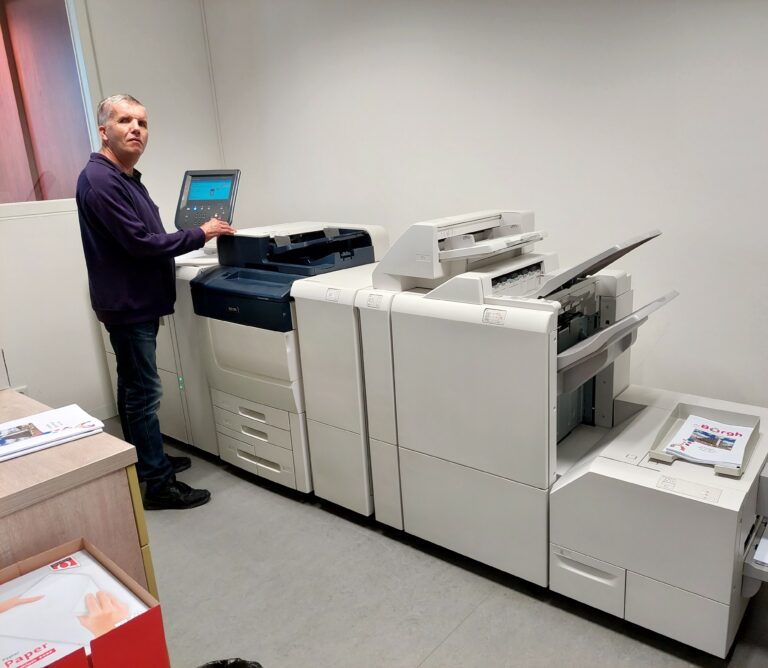 Man staat bij grote kopieermachines