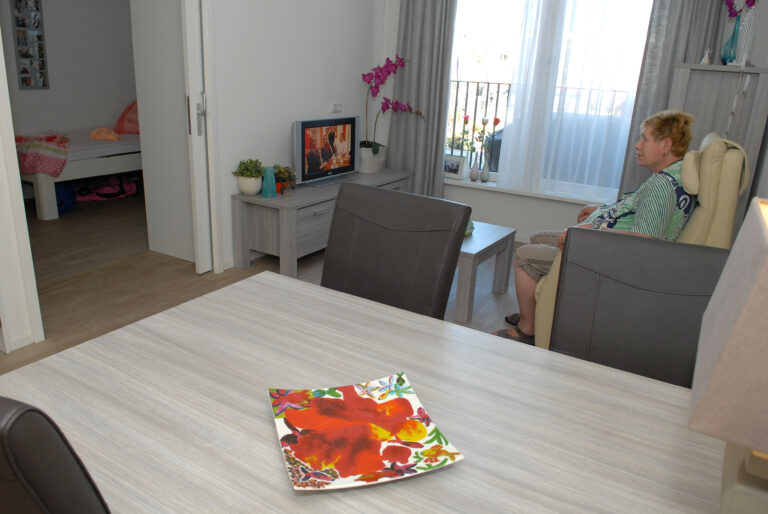 Vrouw zit in een stoel voor de televisie