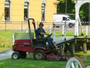 Man in werkkleding op zitmaaier voor Nienoord in Leek