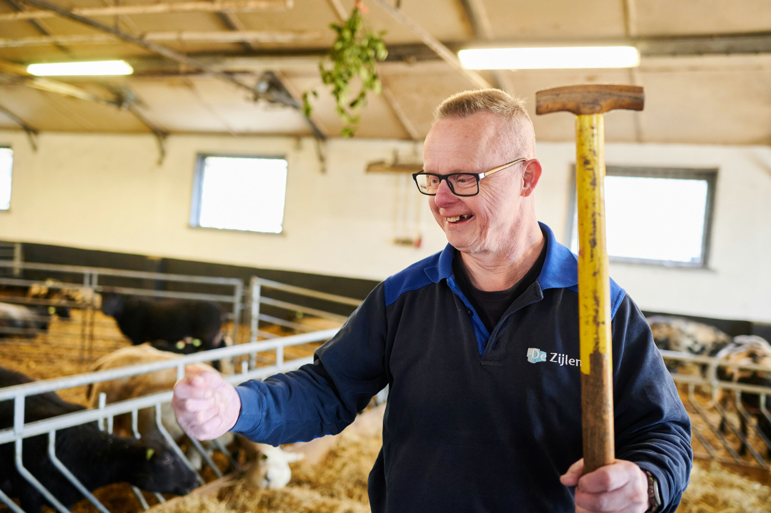 Man met werkkleding van De Zijlen die aan het werk is in een stal