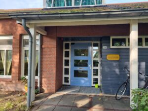 Blauwe voordeur onder overkapping met bordje Amber