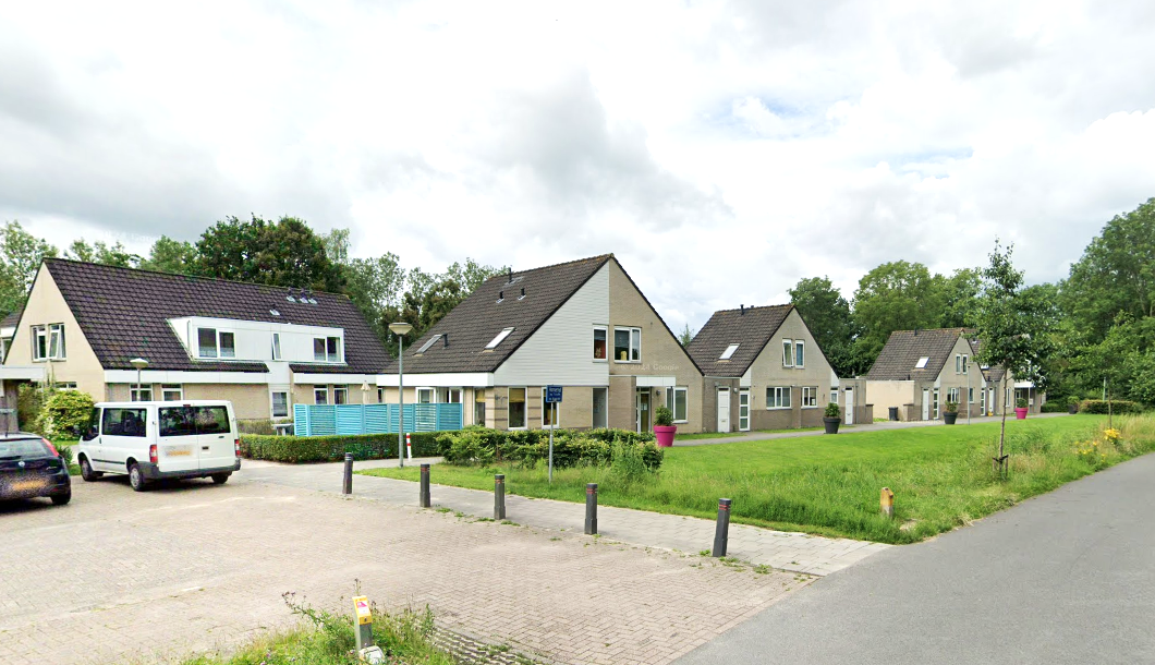 4 grote lichte huizen met grasveld ervoor