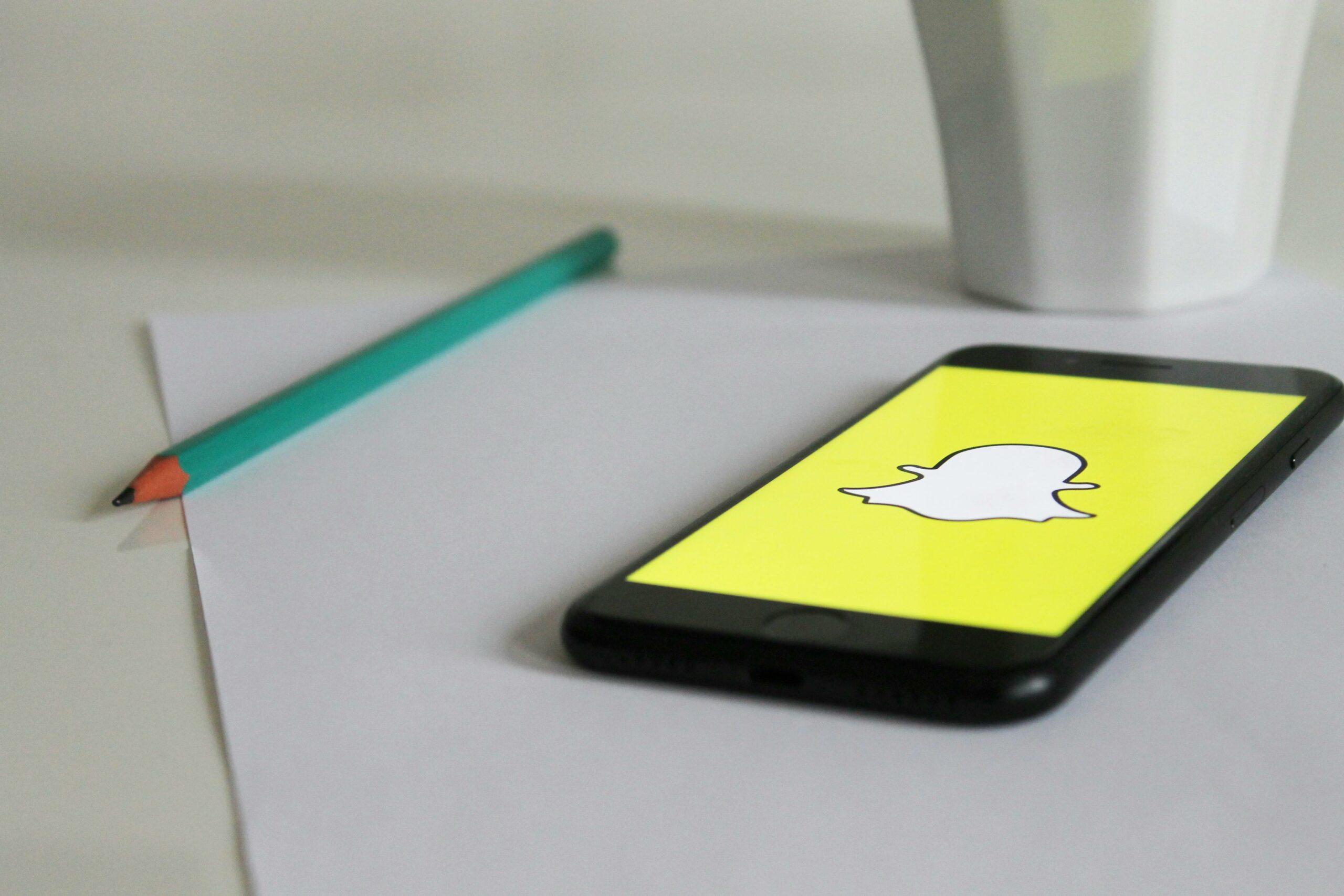 Potlood en telefoon met afbeelding Snapchat