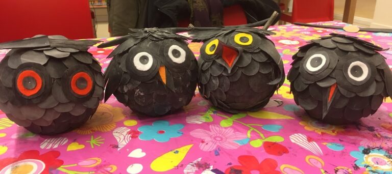 Twee zwarte ballen gemaakt van fietsband met gekleurde ogen op een vrolijk bloemenkleed
