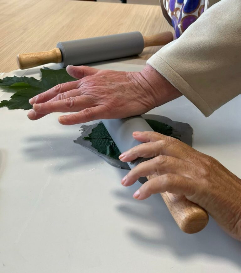 Handen die blaadjes plat maken een deegroller
