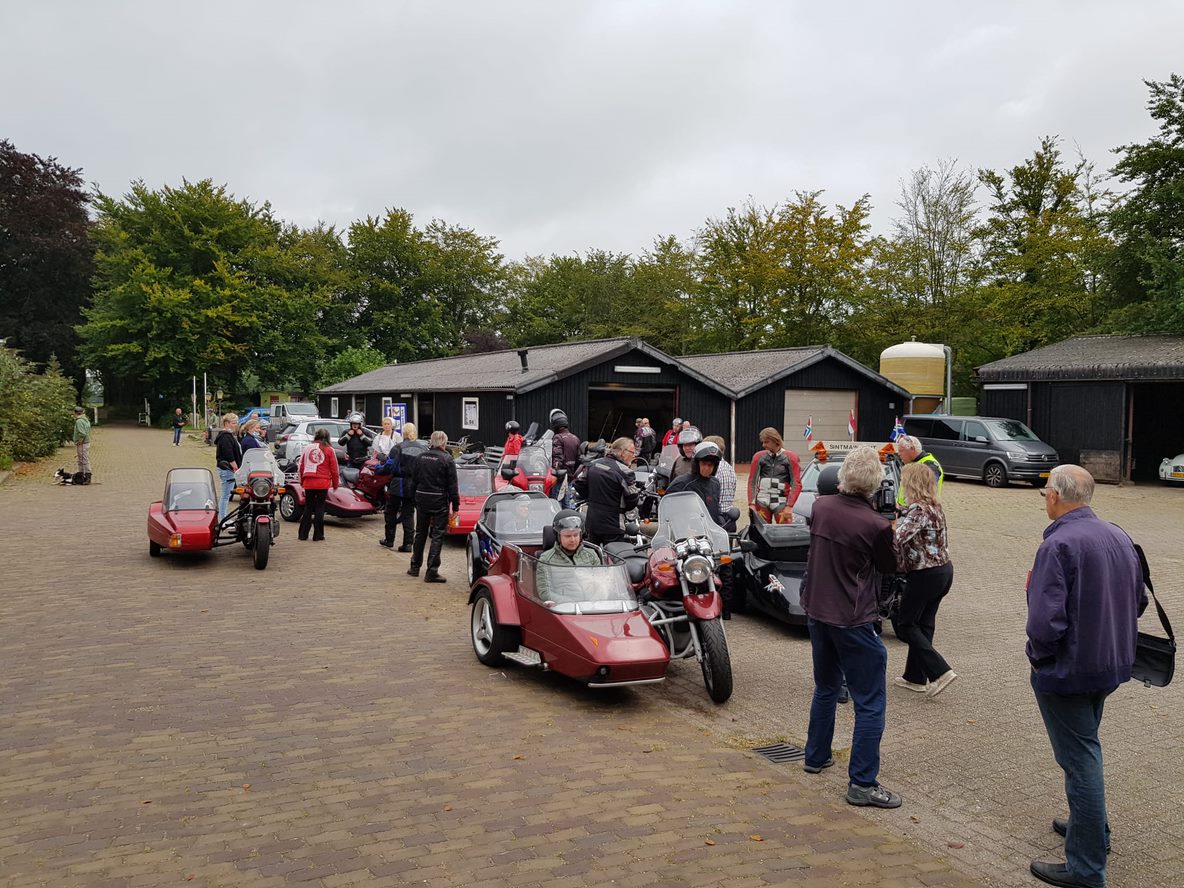 Veel mensen bij elkaar om motoren met zijspannen te bekijken