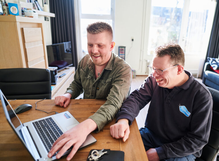 twee mannen achter een laptop