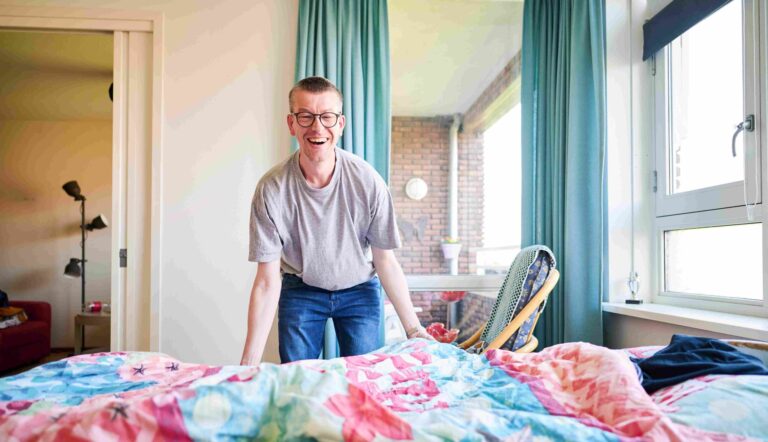Cliënt die in zijn eigen slaapkamer zijn bed opmaakt